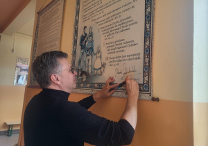 Marek Michalak składa podpis na tablicy praw dziecka w naszej szkole.