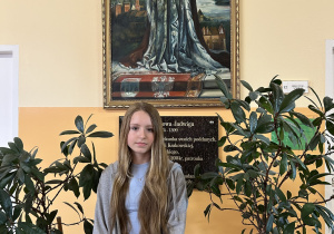 Uczennica Julia Sieruga na tle obrazu Św. Królowej Jadwigi