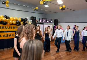 Uczniowie tańczą w kole podczas balu