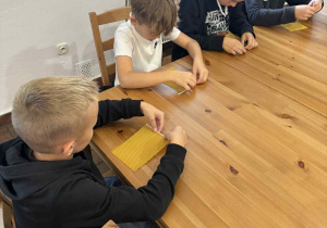 Uczniowie klasy 4 podczas warsztatów robienia świec z wosku w Pałacu w Nieborowie