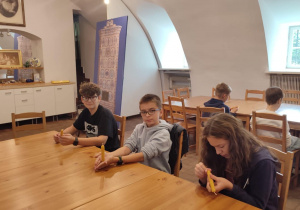 Uczniowie klasy 6 podczas warsztatów robienia świec z wosku w Pałacu w Nieborowie