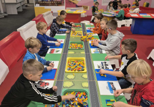 Dzieci wykonują konstrukcje z klocków.