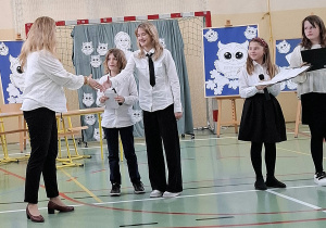 Uczniowie klasy piątej gratulujący Pani od języka polskiego