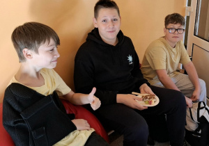 Chłopcy z klasy VI spożywający przekąski podarowane przez klasę VII