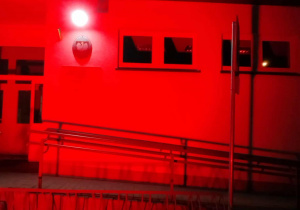 Budynek szkoły Podstawowej w Kalinie rozświetlony na czerwono.