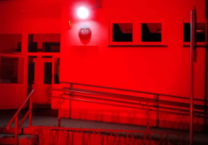 Budynek szkoły Podstawowej w Kalinie rozświetlony na czerwono.