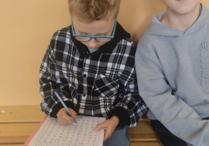 Uczniowie rozwiązują zadania związane z tabliczką mnożenia