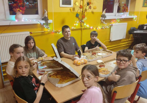 Uczniowie klasy 6 podczas jedzenia pizzy.