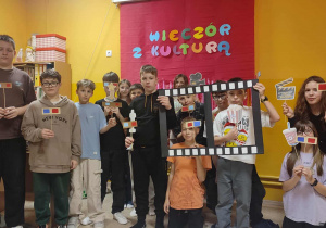 Uczniowie klasy 6 pozują do zdjęcia przy filmowej foto-budce.