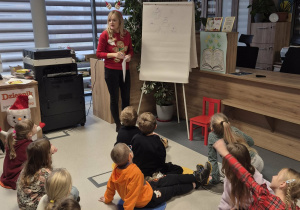 Dzieci oglądają prezentację dotyczącą tradycji swiąt.
