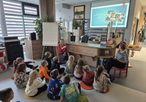 Dzieci słuchają o tradycjach bożonarodzeniowych.