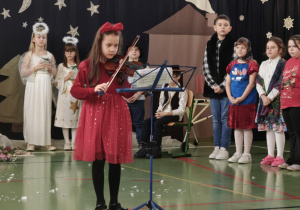 Dziewczynka z klasy 2 gra kolędę na skrzypcach