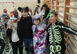 Uczniowie na sali gimnastycznej bawią się podczas balu karnawałowego.