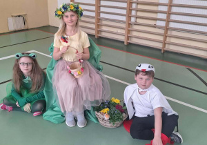 Dzieci w strojach wiosny, żaby i bociana