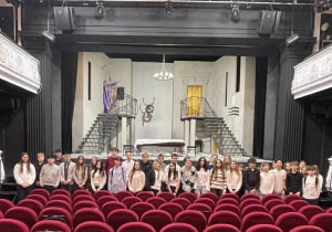 Uczniowie pozują do fotografii na tle sceny teatru im. Stefana Jaracza w Łodzi.