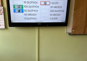 Tablica interaktywna z zadaniem mającym na celu dopasowanie banknotów i monet do wartości