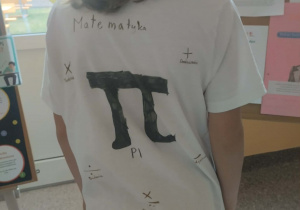 Uczeń przedstawia włesnoręcznie zrobioną matematyczną koszlkę