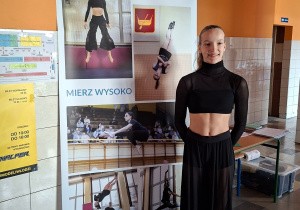 Kasia w stroju przy banerze gimnastycznym