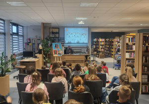 Uczniowie naszej szkoły podczas spotkania autorskiego w Bibliotece Publicznej w Rzgowie słuchają autora Wojciecha Cesarza.