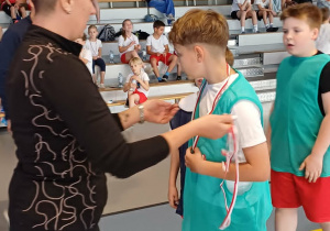 Uczeń klasy trzeciej odbiera medal