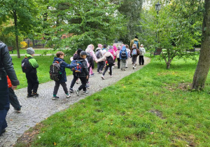 Dzieci idące parkiem wraz z przewodnikiem