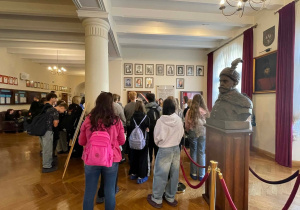Uczniowie podczas wycieczki słuchają przewodnika