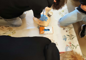 Uczniowie klasy 8 wykonują resuscytację na fantomach