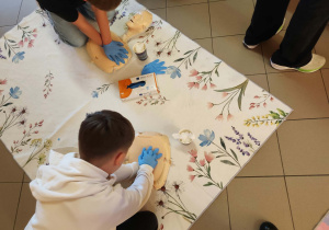 Uczniowie wykonują resuscytację na fantomie